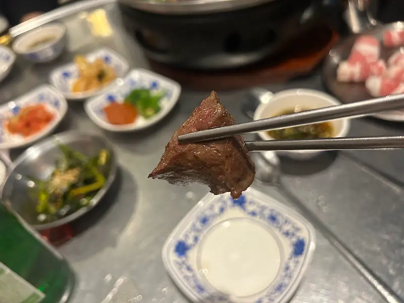 젓가락으로 집어 올린 곱창 한 점