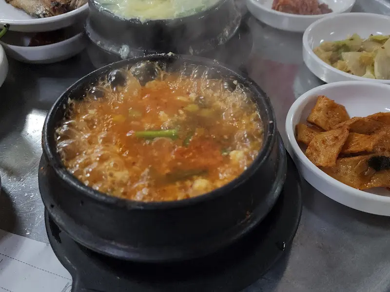 뜨거운 김이 솟아오르는 뚝배기 속 순두부찌개