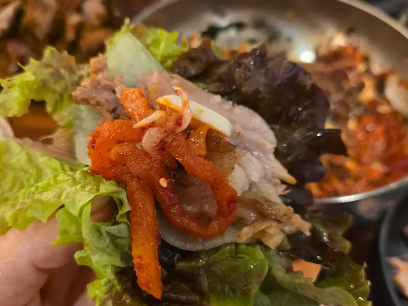 싱싱한 상추에 족발과 곁들임 채소를 올린 쌈