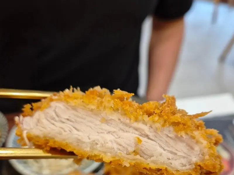 젓가락으로 집어올린 두툼한 돈카츠