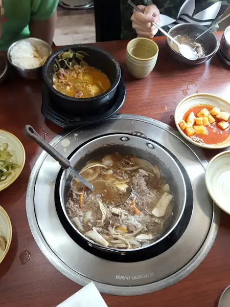 테이블 위에 놓인 여러가지 곁들임 음식과 메인 메뉴인 닭갈비가 보인다.