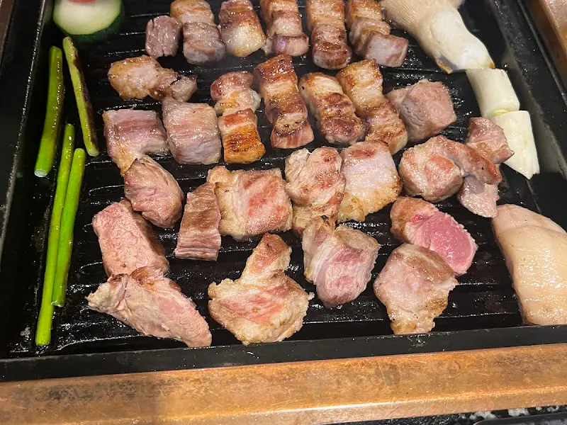 잘 구워진 돼지고기가 석쇠 위에 놓여 있는 모습