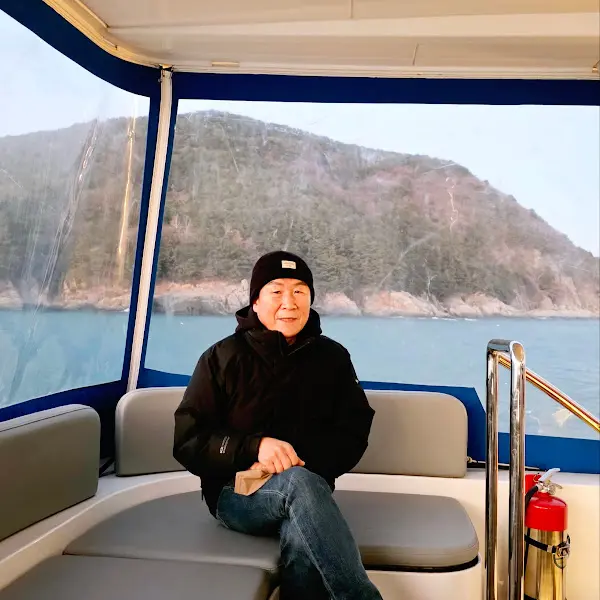 배 위에서 바다를 배경으로 포즈를 취한 사람