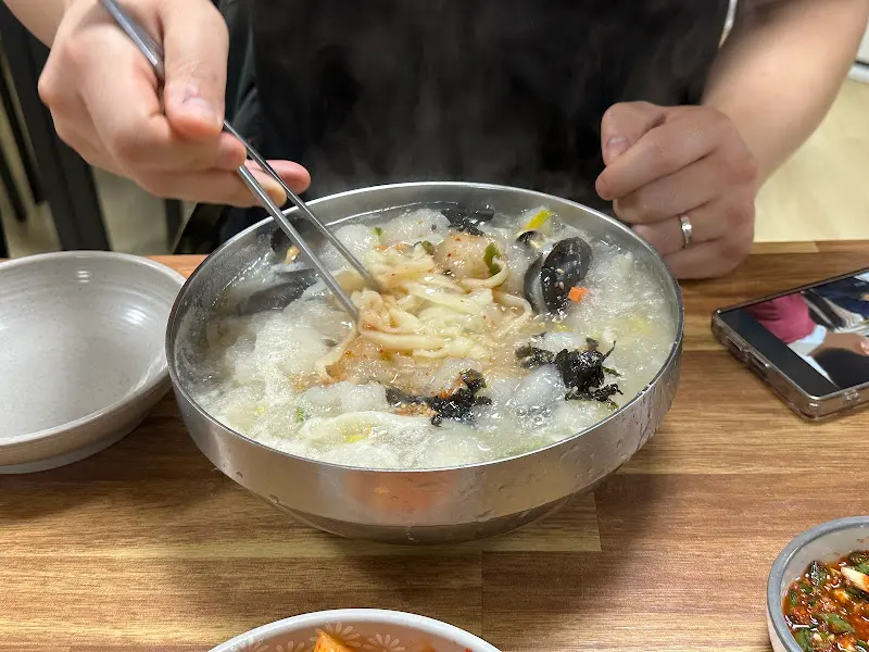 젓가락으로 옹심이칼국수 면을 들어올리는 모습