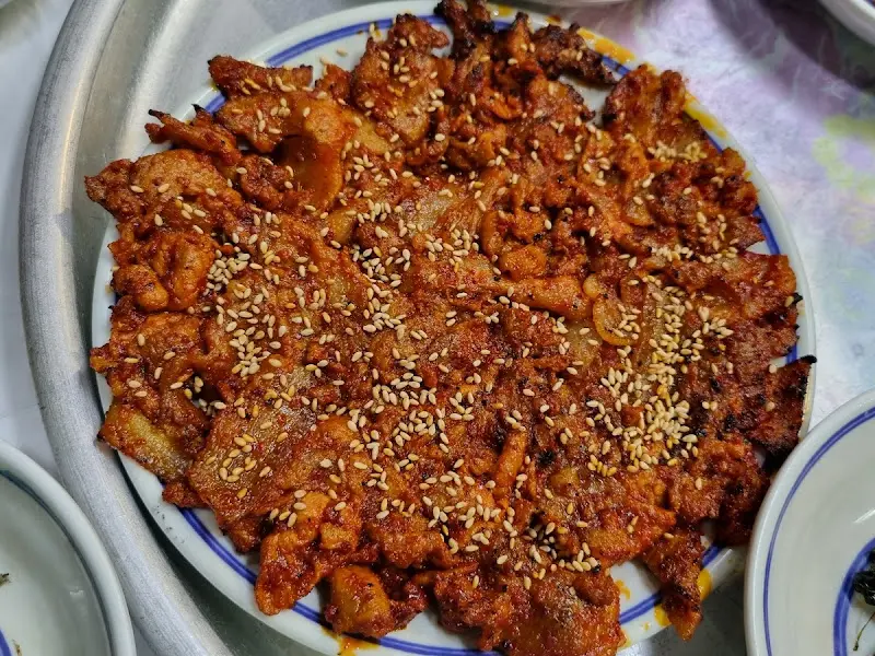 윤기가 흐르고 깨가 듬뿍 뿌려진 돼지 석쇠구이