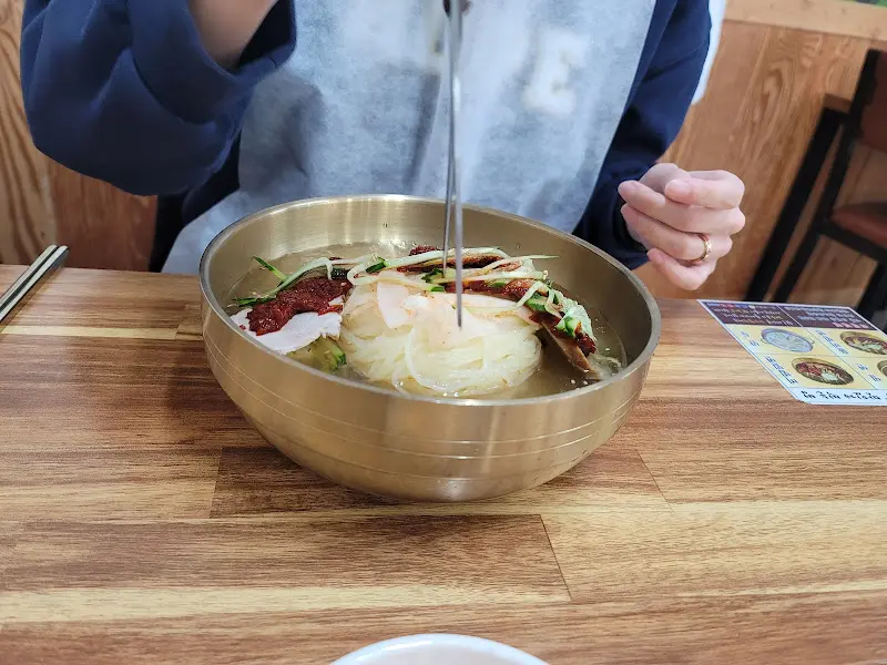 젓가락으로 밀면을 들어올리는 모습