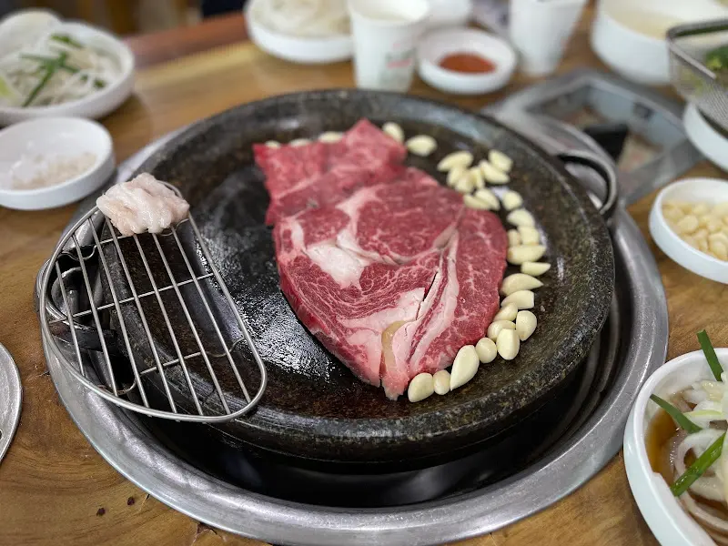 돌판 위에 구워진 마늘과 한우