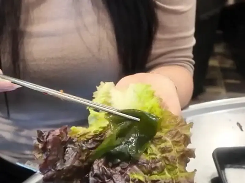 싱싱한 쌈 채소에 고기를 싸 먹는 모습