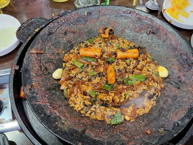 솥뚜껑 위에 펼쳐진 볶음밥 한 상