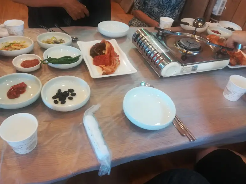 테이블 가득 차려진 밑반찬과 매운탕 냄비