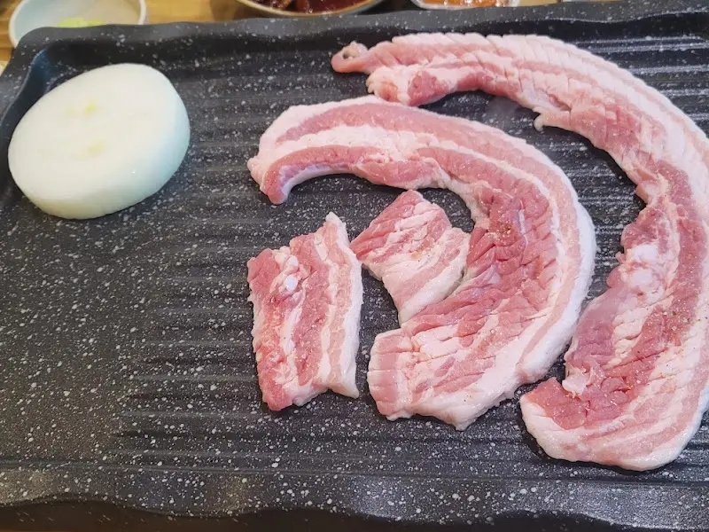 불판 위의 삼겹살과 미나리