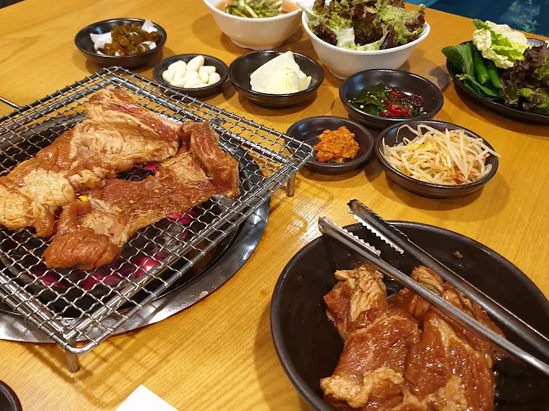 테이블 가득 차려진 반찬과 숯불