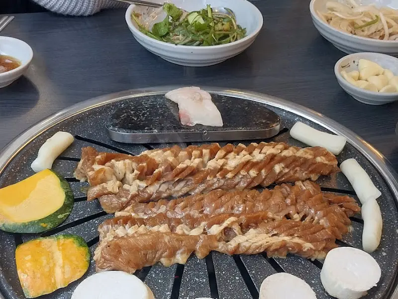 돼지갈비와 다양한 밑반찬이 놓인 테이블