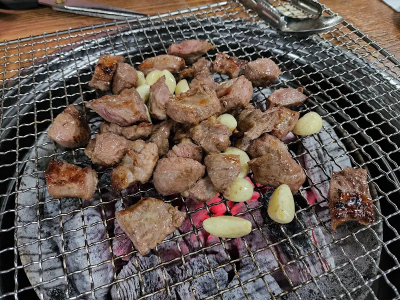 숯불 위에서 익어가는 갈매기살과 마늘