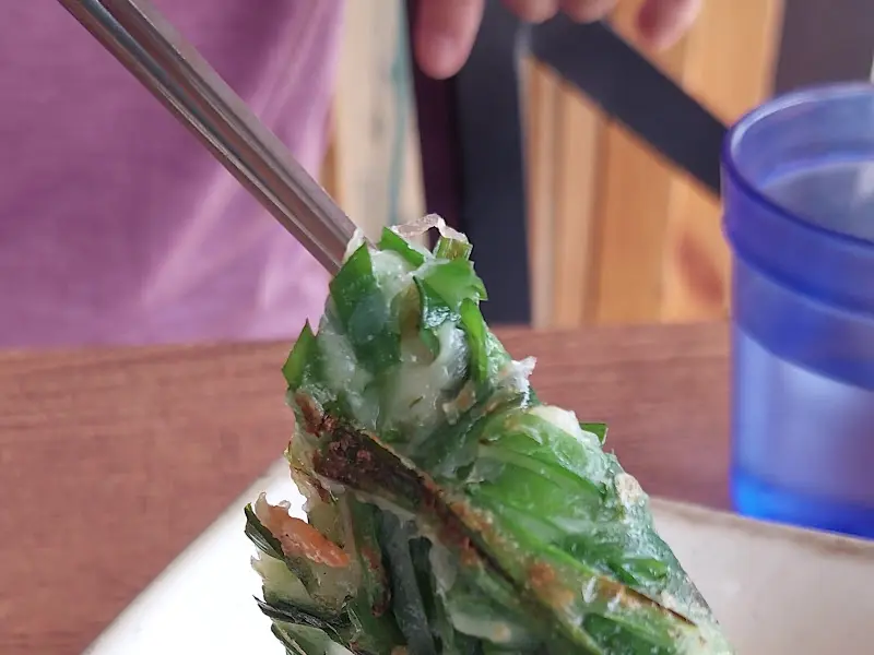 젓가락으로 집어올린 부추전