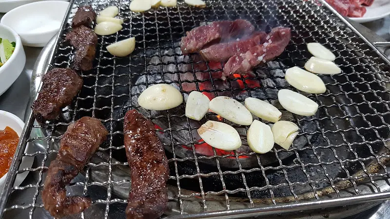 숯불 위에 구워지는 소갈비살과 마늘