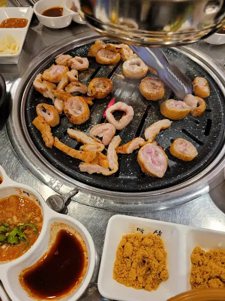 불판 옆에 놓인 김치찌개 뚝배기