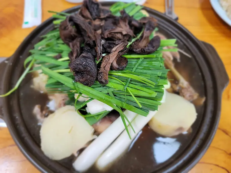 능이버섯과 부추가 듬뿍 올려진 능이오리백숙