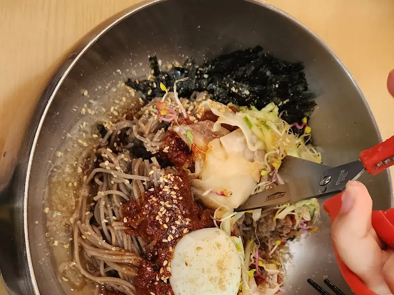 비빔 막국수를 자르는 모습