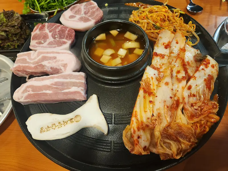 잘 구워진 삼겹살과 다양한 곁들임