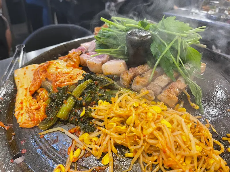 불판 위 삼겹살과 미나리