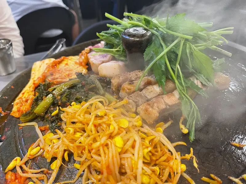 불판 위 삼겹살과 김치, 콩나물