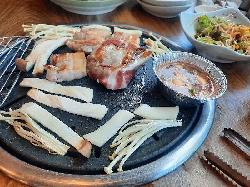 잘 구워진 흑돼지 오겹살과 다양한 곁들임