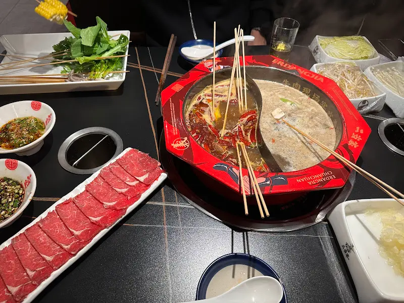 홍탕과 버섯탕에 꼬치를 넣어 익혀 먹는 모습