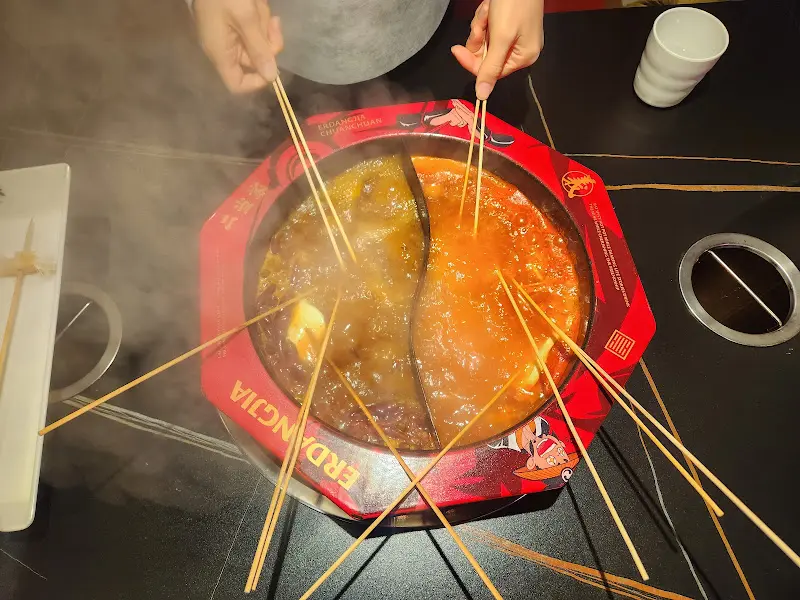 홍탕과 버섯탕에 꼬치를 담가 익히는 모습