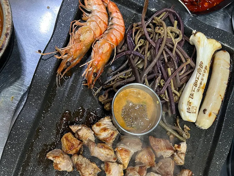 흑돼지, 새우, 고사리가 함께 구워지는 모습