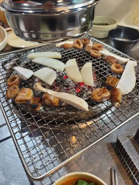 불판 위의 막창, 버섯, 양파