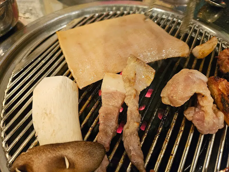불판 위에서 익어가는 돼지 껍데기와 버섯