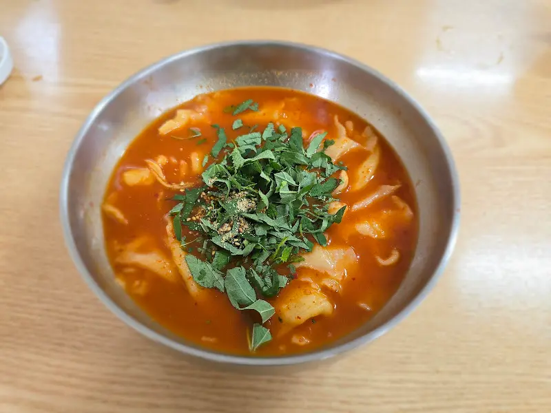 매운 양념과 방아잎이 듬뿍 올라간 매운 칼국수