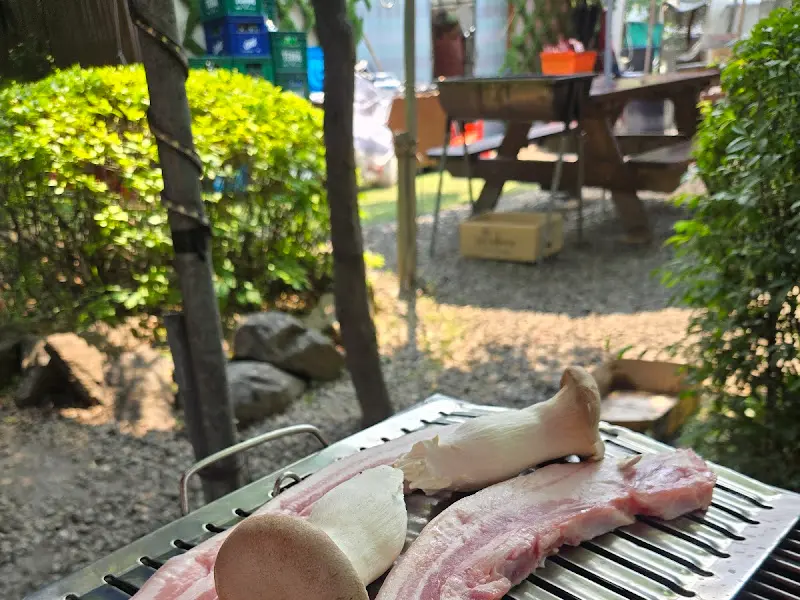 숯불 위에 구워지는 오겹살과 버섯