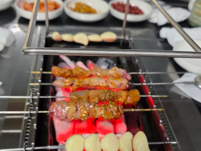 숯불 위에서 익어가는 양꼬치와 마늘