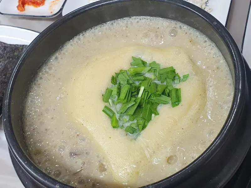 뽀얀 국물 위에 송송 썰린 파가 얹어져 있는 참게가리장의 모습