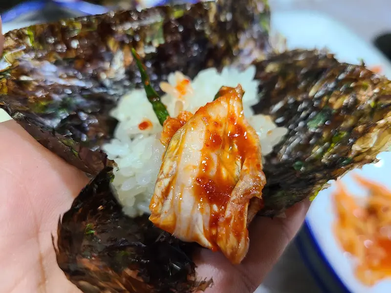김치와 밥을 김에 싸 먹는 모습