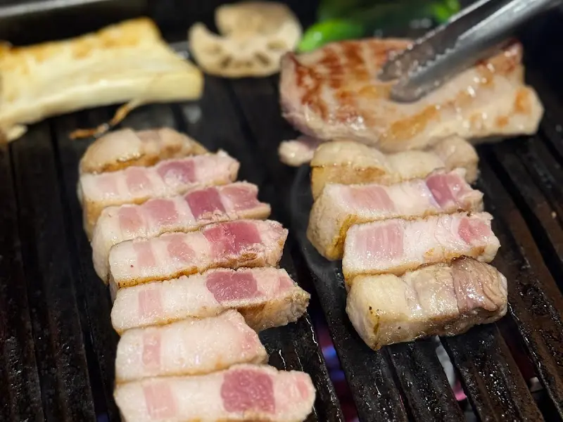 불판 위에서 익어가는 고기의 근접 사진