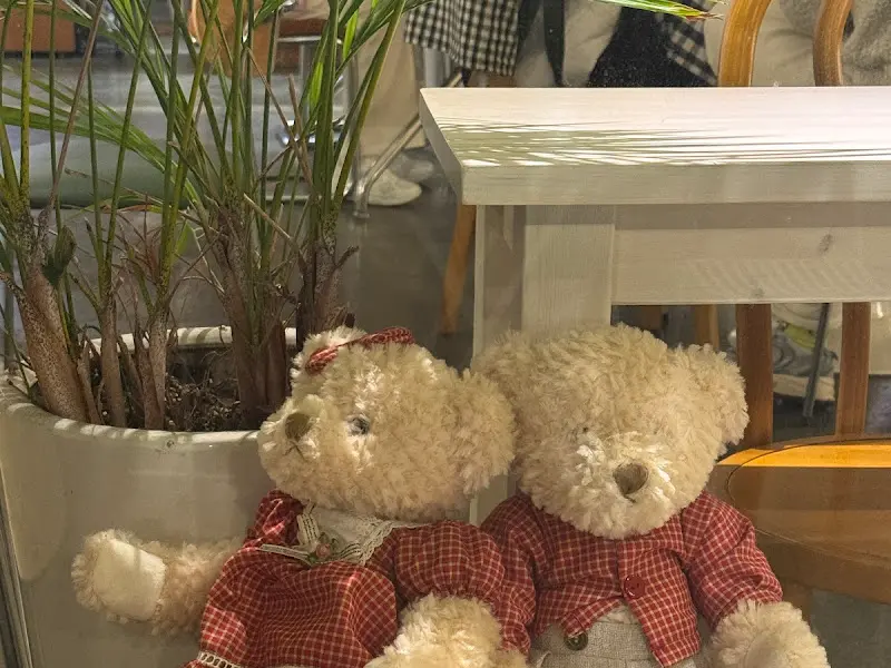 테이블 옆에 놓인 곰인형 두 마리