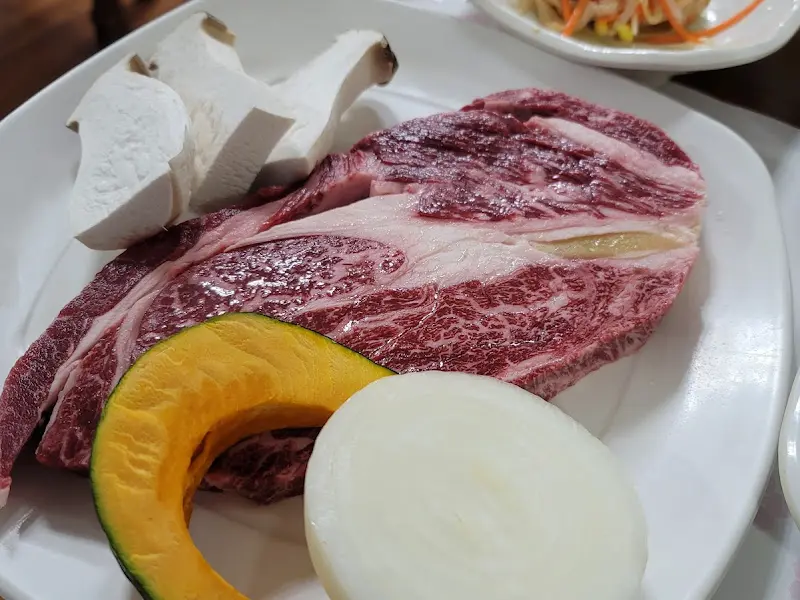 두툼한 등심과 곁들여진 버섯, 양파, 단호박