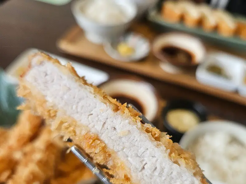 젓가락으로 집어 올린 돈까스 단면