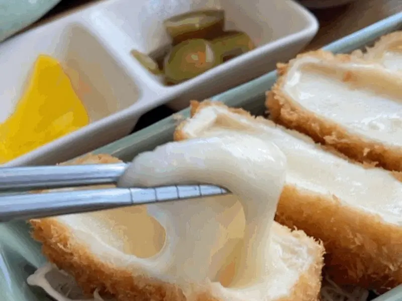 젓가락으로 들어올린 치즈 돈까스