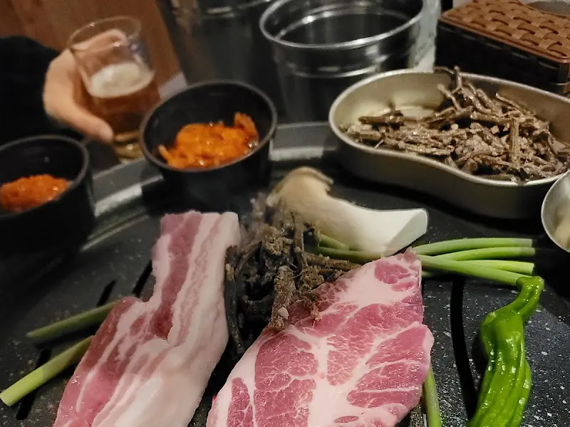 불판 위에 구워지는 삼겹살과 고사리