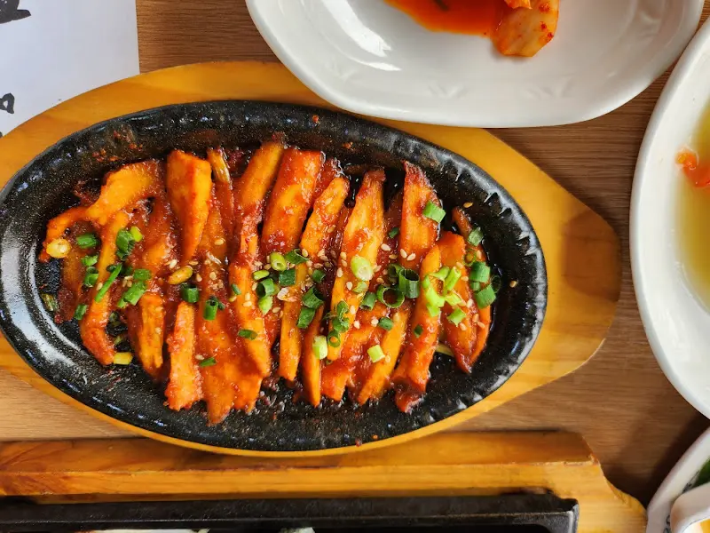 윤기가 흐르는 떡갈비가 뜨거운 철판 위에 가지런히 놓여있다.