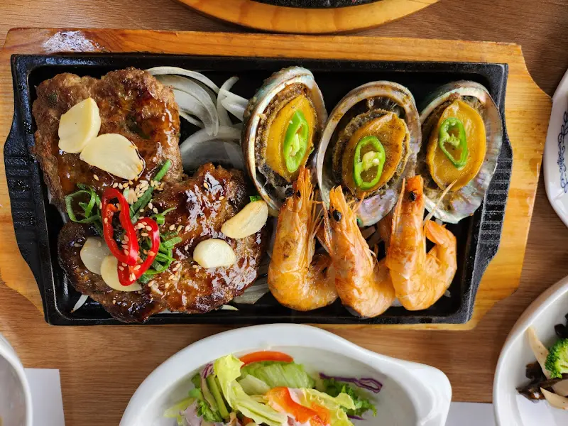 떡갈비와 전복, 새우가 함께 놓여진 화려한 플레이팅