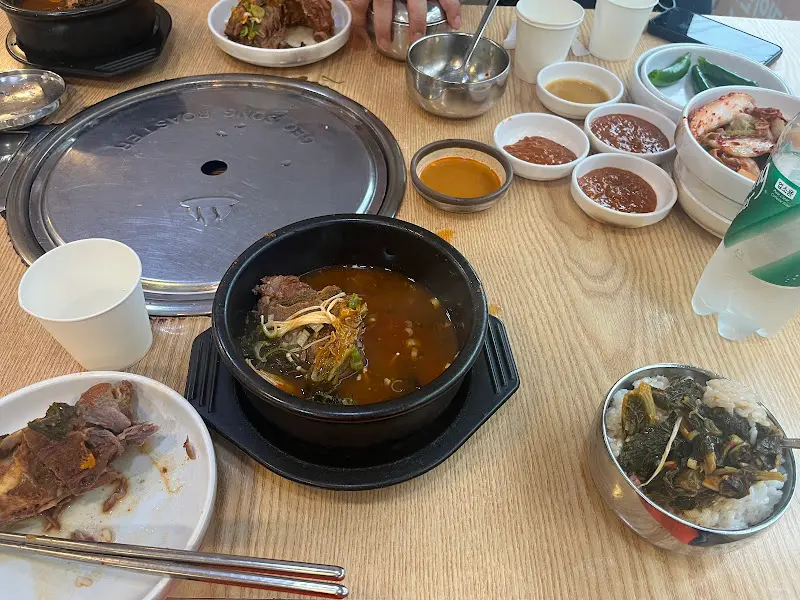 테이블 위에 놓인 감자탕과 다양한 반찬들