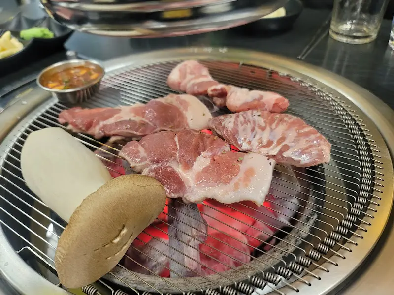 불판 위에 올려진 뒷고기와 버섯