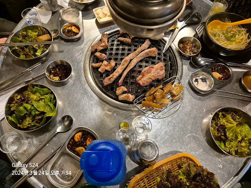 불판 위에서 익어가는 고기와 푸짐한 상차림