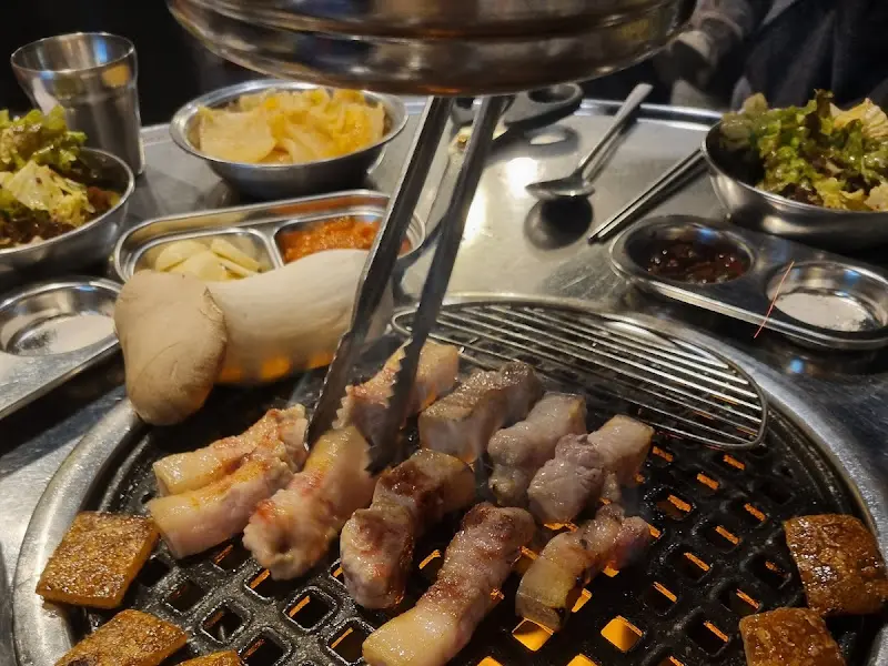 잘 구워진 고기를 집게로 집는 모습