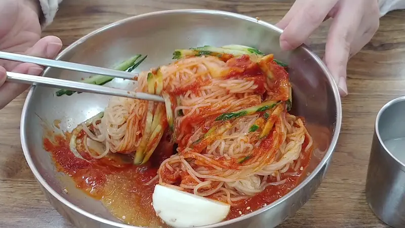 젓가락으로 밀면을 들어올리는 모습